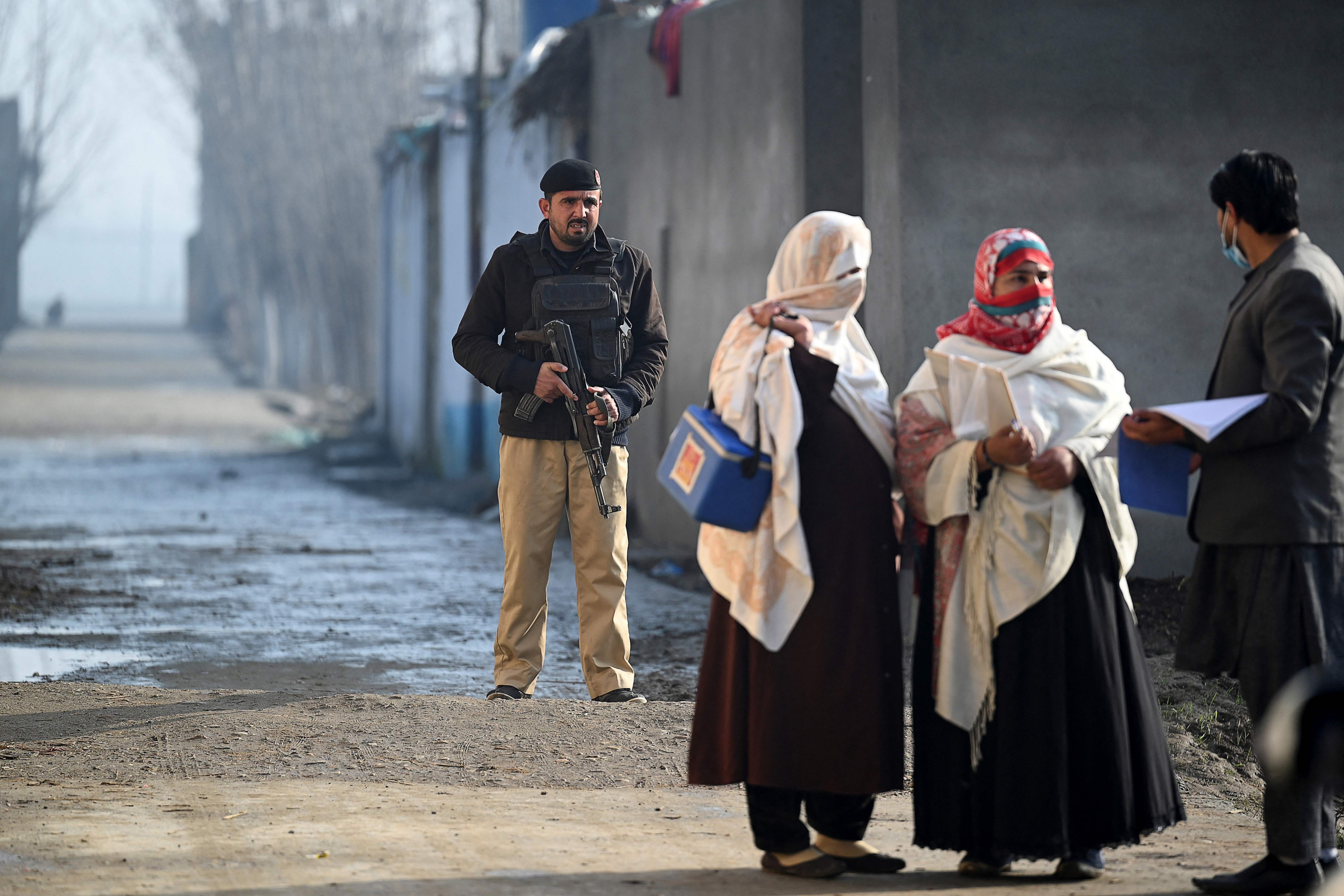 Pakistan is one of two countries - with Afghanistan - where polio still remains endemic. In photo- a policeman escorts health workers during a door-to-door polio vaccination campaign on the outskirts of Mardan, in Khyber Pakhtunkhwa province on January 24, 2022. (AFP file photo. ) Pakistan is one of two countries - with Afghanistan - where polio still remains endemic. In photo- a policeman escorts health workers during a door-to-door polio vaccination campaign on the outskirts of Mardan, in Khyber Pakhtunkhwa province on January 24, 2022. (AFP file photo. )