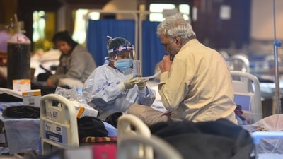 A patient being attended by a healthcare worker in Delhi Covid-19 care facility. (Raj K Raj/HT Photo) A patient being attended by a healthcare worker in Delhi Covid-19 care facility. (Raj K Raj/HT Photo)