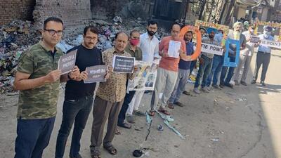 PAC members protesting in front of the open garbage dump at Saidan Chowk in Ludhiana on April 24. (Harvinder Singh/HT)