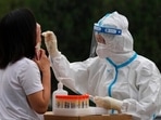 A medical worker takes a swab sample from a resident during mass testing for COVID-19 in the Chaoyang district in Beijing. A medical worker takes a swab sample from a resident during mass testing for COVID-19 in the Chaoyang district in Beijing. 