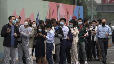 Residents and office workers wearing masks line up for mass Covid testing near the commercial office complex in Chaoyang district, Beijing, China on Monday. (AP) Residents and office workers wearing masks line up for mass Covid testing near the commercial office complex in Chaoyang district, Beijing, China on Monday. (AP)