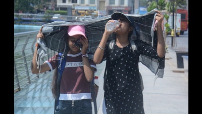 Two young girls cover their heads as they walk while drinking water in the scorching afternoon heat as the mercury rises in Thane (Praful Gangurde/HT Photo) Two young girls cover their heads as they walk while drinking water in the scorching afternoon heat as the mercury rises in Thane (Praful Gangurde/HT Photo)