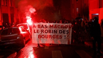 People attend a demonstration after the announcement of results of the 2022 French presidential election. Banner reads: "Down with Macron, Robin [Hood] of the bourgeoisie"&nbsp; (REUTERS/Stephane Mahe)