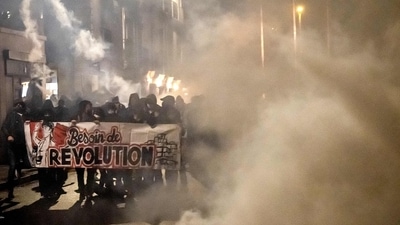 Protesters hold a banner reading "a need for revolution" in Nantes on April 24, 2022, following the results of the French presidential elections. (Photo by Loic VENANCE / AFP) Protesters hold a banner reading "a need for revolution" in Nantes on April 24, 2022, following the results of the French presidential elections. (Photo by Loic VENANCE / AFP)