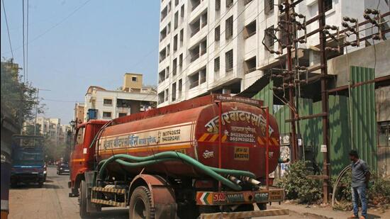 A tanker seen supplying water to residential societies on Jambhulwadi road on Monday. (Ravindra Joshi/HT PHOTO)