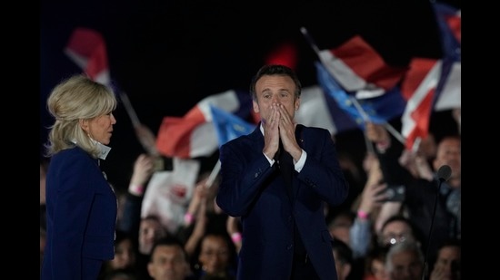 French President Emmanuel Macron and French first lady Brigitte Macron celebrate with supporters in Paris, France, April 24, 2022 (AP)