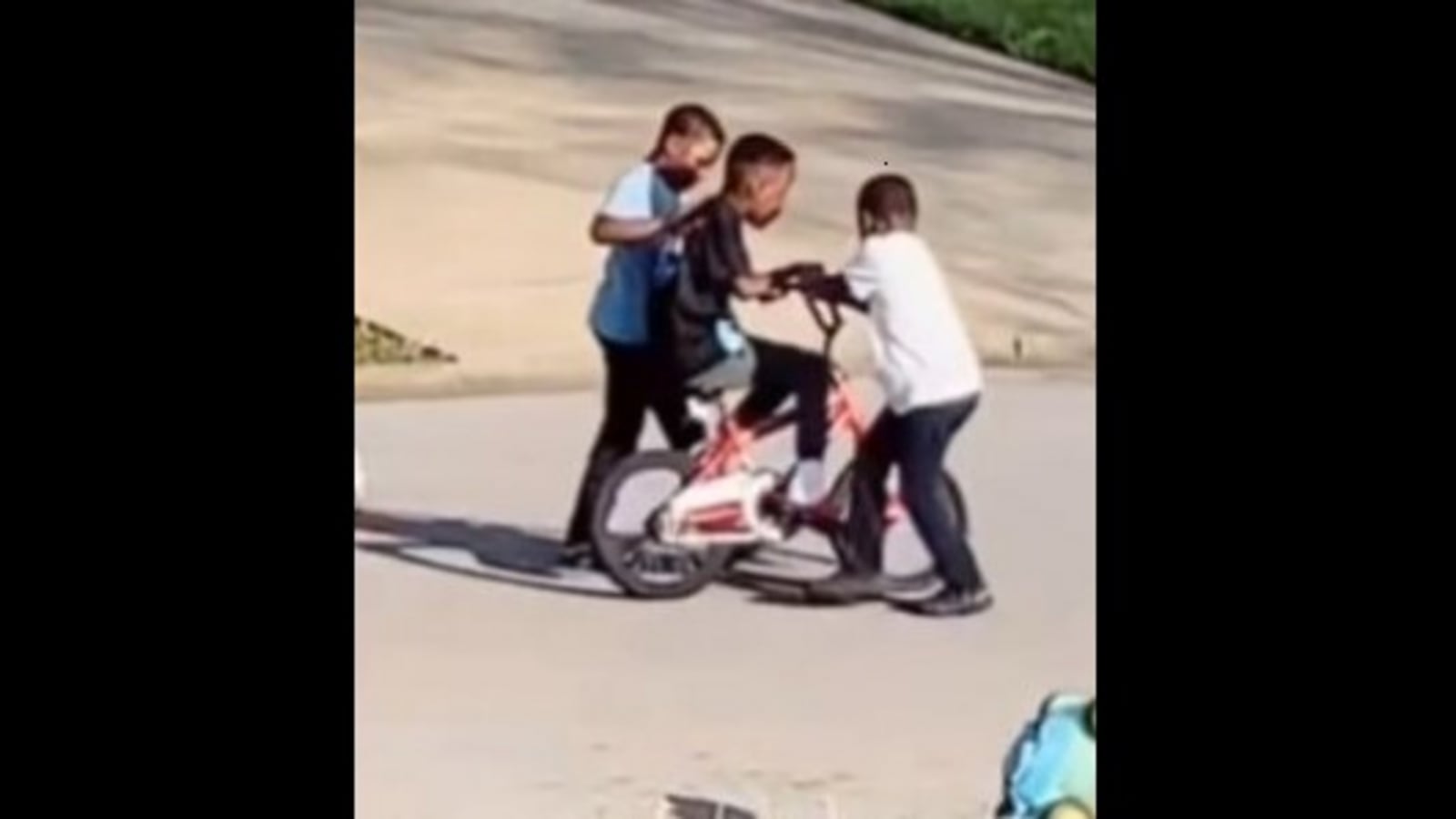 Little kids help their neighbourhood friend learn how to ride a bicycle ...