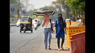 Women seen using scarves and umbrellas to protect themselves from the heat. (HT PHOTO) Women seen using scarves and umbrellas to protect themselves from the heat. (HT PHOTO)