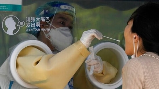 A worker takes a swab sample at a Covid test center on Tuesday in Beijing.&nbsp;(AP)