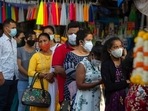 People wearing face masks wait for their turn to enter a church,
