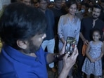 Chiranjeevi clicks son Ram Charan's pic with fans. Chiranjeevi clicks son Ram Charan's pic with fans.