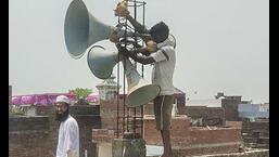 Workers remove loudspeakers from a religious building, in Gorakhpur, on Wednesday. The Uttar Pradesh government has ordered the removal of loudspeakers from all religious sites while raising awareness on noise pollution. (PTI Photo)
