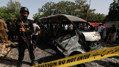 A police officer stands guard near a passenger van, cordoned after a blast at the entrance of the Confucius Institute University of Karachi, Pakistan, April 26, 2022. REUTERS/Akhtar Soomro (REUTERS)