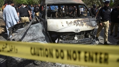 Police inspect a site around damaged vehicles following a suicide bombing near the Confucious Institute affiliated with the Karachi University, in Karachi on April 26, 2022. (AFP) Police inspect a site around damaged vehicles following a suicide bombing near the Confucious Institute affiliated with the Karachi University, in Karachi on April 26, 2022. (AFP)