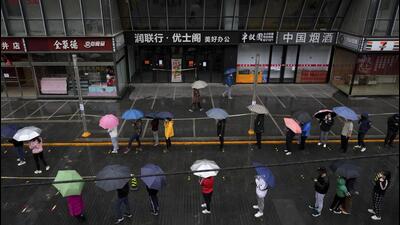 Locked-down residents line up in the rain for Covid test outside shuttered office complex in Beijing, on Wednesday. (AP) Locked-down residents line up in the rain for Covid test outside shuttered office complex in Beijing, on Wednesday. (AP)