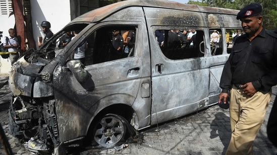 Police inspect a site around damaged vehicles following a suicide bombing near the Confucious Institute affiliated with the Karachi University.&nbsp;(AFP)