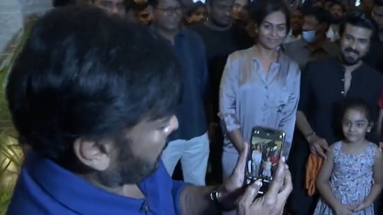 Chiranjeevi clicks son Ram Charan's pic with fans.