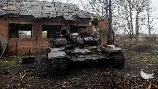 A Ukrainian soldier jumps of a destroyed Russian tank in Kharkiv region, Ukraine.