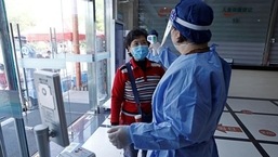 A worker in a protective suit measures the body temperature of a woman during a vaccination session against Covid-19 for elderly people, at a community health service centre in Fengxian district of Shanghai, China. (REUTERS)