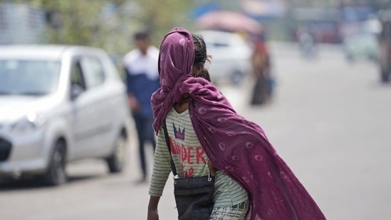 A girl covers her face with a scarf to protect herself from the sun on a hot summer afternoon in the outskirts of Jammu, India, Thursday, April 28, 2022. (AP Photo/Channi Anand) (AP)