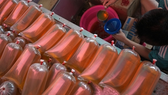 A shopkeeper packages cooking oil at Kambing Market in Jakarta, Indonesia, on Thursday.(Bloomberg)