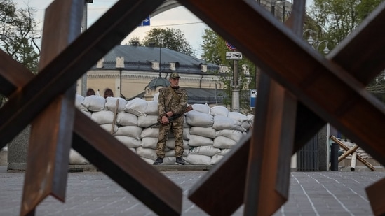 A serviceman stands guard next to anti-tank constructions, amid Russia's invasion of Ukraine, in central Kyiv, Ukraine.(REUTERS)
