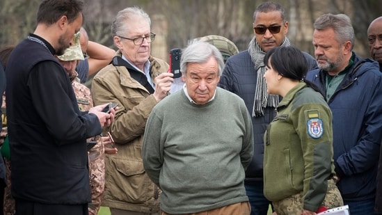 UN secretary-general Antonio Guterres, center, stands on the side of a mass grave in Bucha, on the outskirts of Kyiv, Ukraine, on Thursday, April 28, 2022. (AP Photo/Efrem Lukatsky)