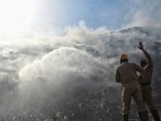 Firefighters douse a fire at Bhalswa landfill, in New Delhi.