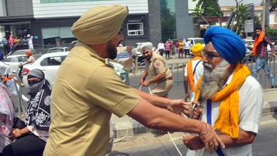 Police personnel stops the protester during the clash that erupted between two groups near Kali Devi Temple, in Patiala on Friday. (ANI Photo) (Ajay Sharma) Police personnel stops the protester during the clash that erupted between two groups near Kali Devi Temple, in Patiala on Friday. (ANI Photo) (Ajay Sharma)