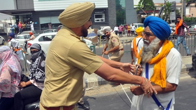 Police personnel stops the protester during the clash that erupted between two groups near Kali Devi Temple, in Patiala. (Ajay Sharma) Police personnel stops the protester during the clash that erupted between two groups near Kali Devi Temple, in Patiala. (Ajay Sharma)