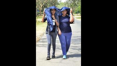 Two girls taking a walk on a sultry day in Ludhiana as temperature reached a record high of 43.2°C.) (Harvinder Singh/HT) Two girls taking a walk on a sultry day in Ludhiana as temperature reached a record high of 43.2°C.) (Harvinder Singh/HT)