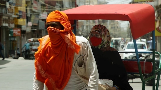 A rickshaw puller covers his face from the heatwave as temperature touches 44 degrees, in New Delhi on Wednesday. (ANI Photo)
