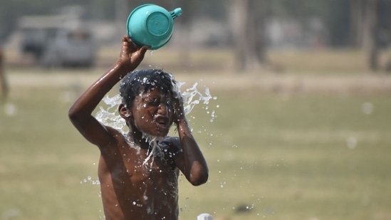 A child cools off on a hot day at a public tap in Prayagraj. (Anil Kumar Maurya/HT)(HT_PRINT)