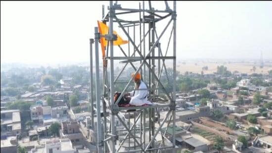 A Sikh man climbed atop a cell tower at Rode village in Baghapurana subdivision of Moga district on Friday. (HT Photo)