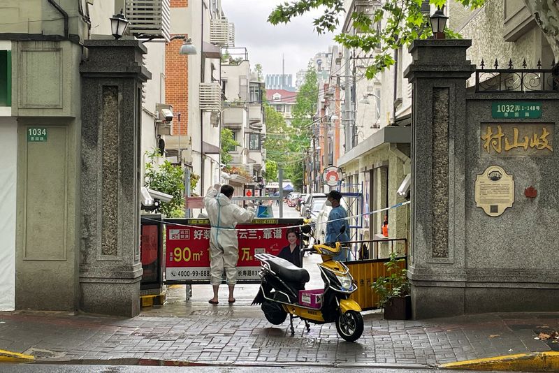 A courier in a protective suit makes deliveries to a residential compound amid the coronavirus disease outbreak in Shanghai, China.(Reuters)
