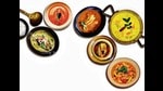 Any spiced dish with a gravy, of Indian origin or influence, cooked in a pot, qualifies as a curry, Sukhadwala says. (Clockwise from bottom right) Curries from Malaysia, Thailand, Goa, Bengal, the Malabar coast, and Assam. (HT Archives) Any spiced dish with a gravy, of Indian origin or influence, cooked in a pot, qualifies as a curry, Sukhadwala says. (Clockwise from bottom right) Curries from Malaysia, Thailand, Goa, Bengal, the Malabar coast, and Assam. (HT Archives)