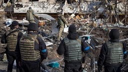 Soldados ucranianos inspecionam os escombros de um prédio de apartamentos destruído em Kiev.