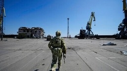 Guerra na Ucrânia: Um soldado russo caminha enquanto guarda uma área do porto marítimo de Mariupol, em Mariupol, em território sob o governo da República Popular de Donetsk, leste da Ucrânia, 