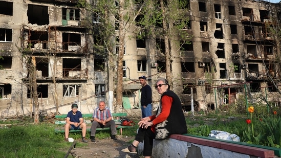 Local residents sit in the yard of their damaged building in Mariupol, eastern Ukraine, Friday.(AP) Local residents sit in the yard of their damaged building in Mariupol, eastern Ukraine, Friday.