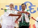 Delhi chief minister Arvind Kejriwal with Bharatiya Tribal Party (BTP) founder Chhotubhai Vasava holds a bow and an arrow during the 'Adivasi Sankalp Mahasammelan' in Bharuch on Sunday.(ANI)