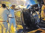 Police officers examine the wreckage of the car on Sunday.