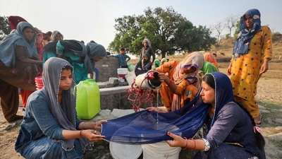 Women use a cloth to filter drinking water after collecting it from a well at Padal village in Samba district on Sunday. (PTI) Women use a cloth to filter drinking water after collecting it from a well at Padal village in Samba district on Sunday. (PTI)