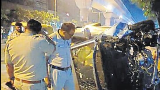 Police officers examine the wreckage of the car on Sunday.