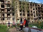 Local residents sit in the yard of their damaged building in Mariupol. (AP) Local residents sit in the yard of their damaged building in Mariupol. (AP)