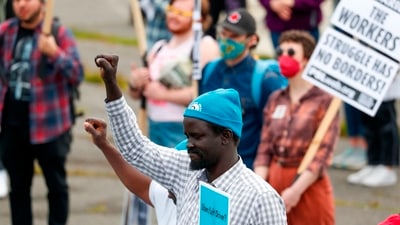 Workers from the Drivers Union raise their fists before the start of the annual May Day March in Seattle. (AP) Workers from the Drivers Union raise their fists before the start of the annual May Day March in Seattle. (AP)