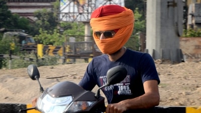 A man uses a piece of fabric while riding a two-wheeler, to shield his face during a heatwave, in Amritsar. (PTI) A man uses a piece of fabric while riding a two-wheeler, to shield his face during a heatwave, in Amritsar. (PTI)