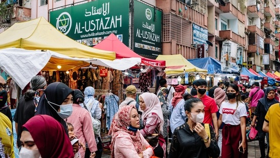 Shoppers walk through a market in Kuala Lumpur, Malaysia, on Sunday. Shoppers prepare for upcoming Eid al-Fitr celebrations, also known as Hari Raya in Malaysia, after a month of fasting.&nbsp;(Bloomberg)