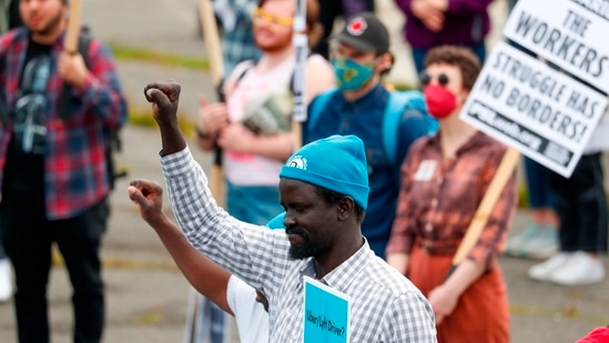 Workers from the Drivers Union raise their fists before the start of the annual May Day March in Seattle. (AP)