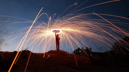 A Palestinian youth swirls fireworks in Gaza City on Monday on the eve of Eid al-Fitr. Saudi Arabia Supreme Court and the moon sighting committees in the UAE, Qatar, Kuwait, Bahrain, Jordan, Morocco, Muscat, Yemen, Sudan, Egypt, Tunisia, Iraq, Syria, Palestine and other Arab states have already announced that Muslims in these countries will celebrate Eid-ul-Fitr on Monday.(AFP)