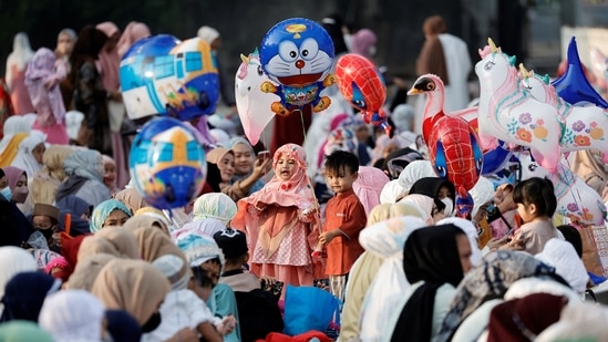 Children hold balloons while attending mass prayers at the Sunda Kelapa port during Eid al-Fitr, marking the end of the holy fasting month of Ramadan, in Jakarta, Indonesia on Monday.(REUTERS)